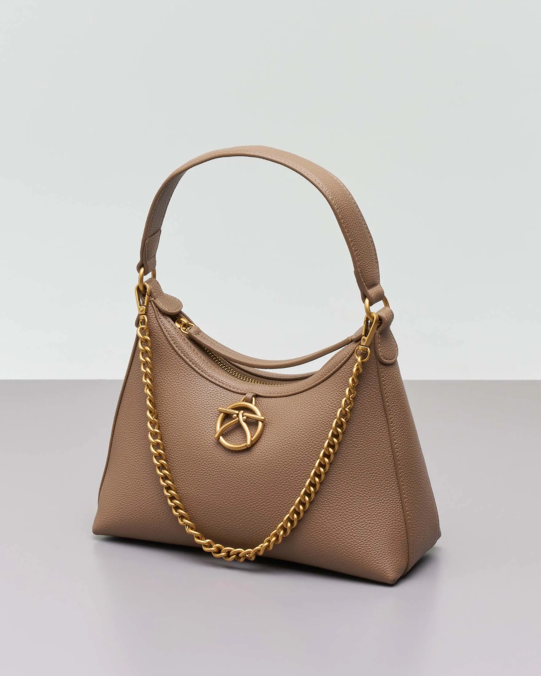 Borsa a spalla a mezzaluna color taupe in similpelle martellata con charm logo e catena dorati